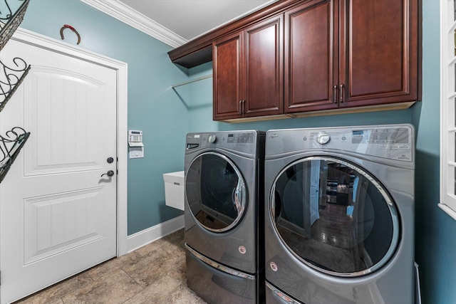 washroom featuring crown molding, washer and clothes dryer, and cabinets