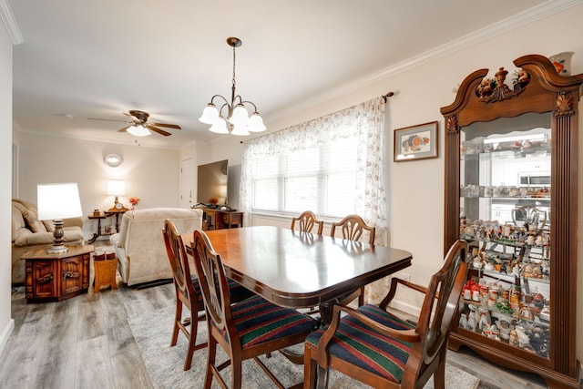 dining space with ceiling fan with notable chandelier, light hardwood / wood-style floors, and crown molding