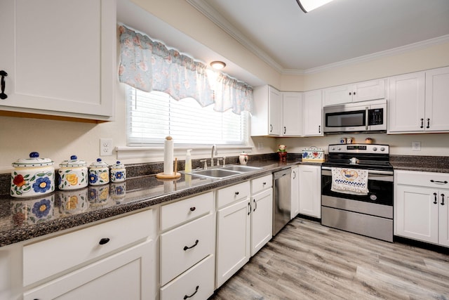 kitchen with ornamental molding, stainless steel appliances, sink, light hardwood / wood-style flooring, and white cabinetry