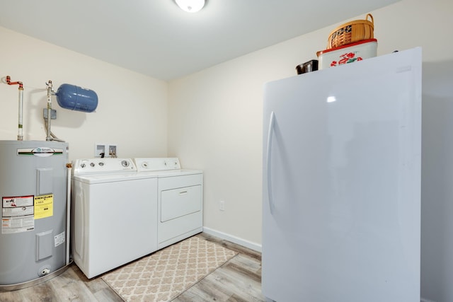 laundry area with light wood-type flooring, washer and clothes dryer, and water heater