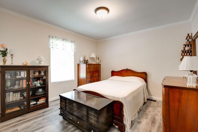 bedroom featuring light hardwood / wood-style floors and ornamental molding