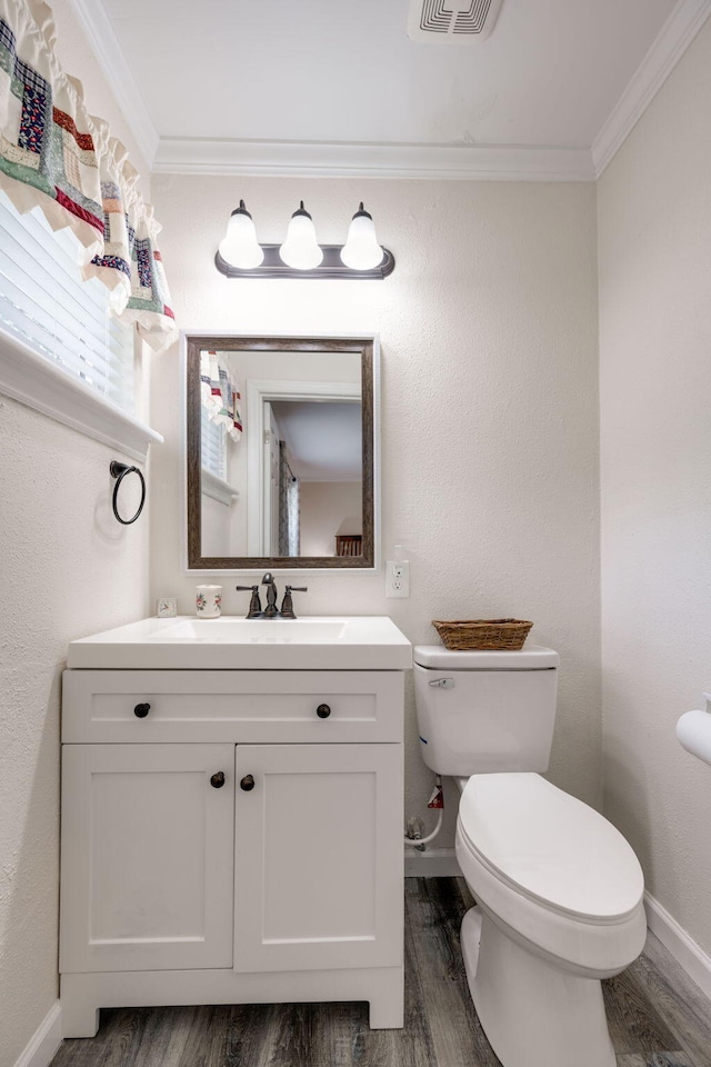 bathroom with hardwood / wood-style flooring, vanity, toilet, and crown molding