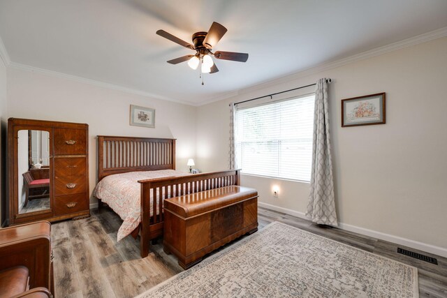 bedroom with wood-type flooring, ceiling fan, and ornamental molding