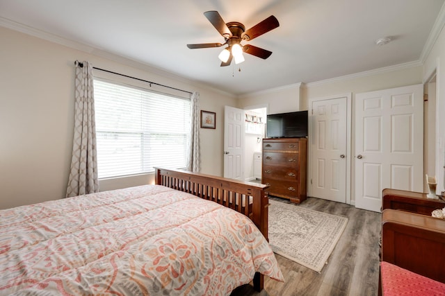 bedroom featuring ceiling fan, light hardwood / wood-style floors, and ornamental molding