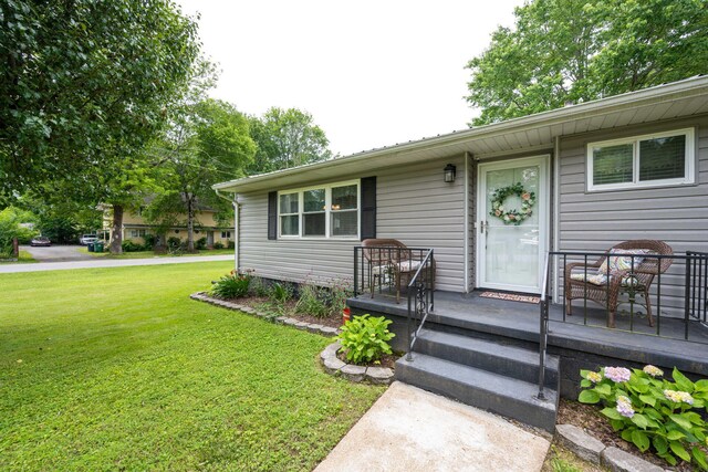 view of exterior entry with a lawn