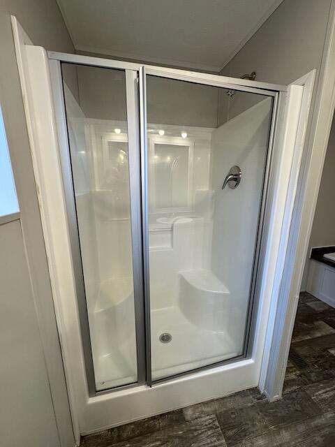 bathroom featuring wood-type flooring and an enclosed shower