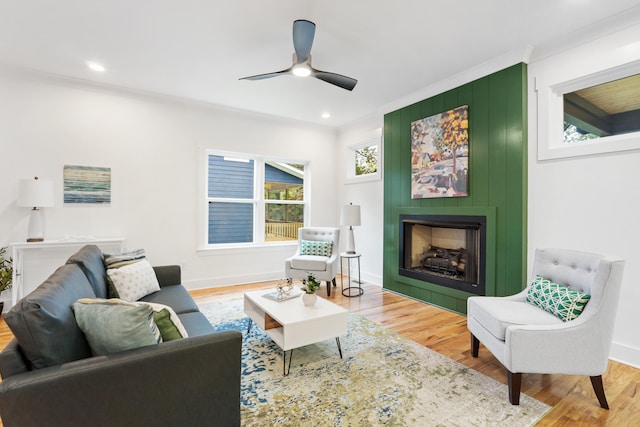 living room with a fireplace, wood-type flooring, plenty of natural light, and ornamental molding