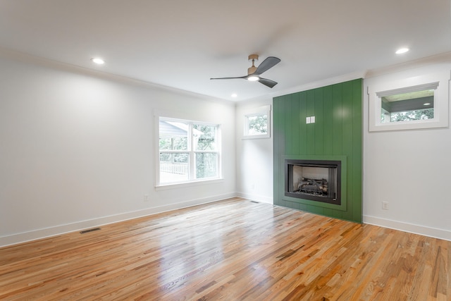 unfurnished living room with a fireplace, light hardwood / wood-style flooring, ceiling fan, and crown molding