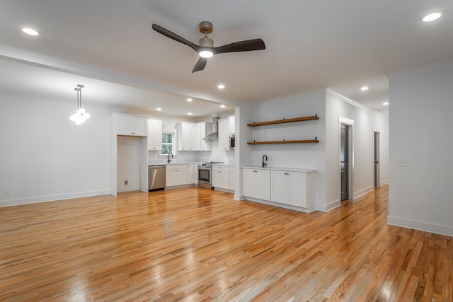 kitchen featuring light hardwood / wood-style flooring, ceiling fan, decorative light fixtures, white cabinetry, and stainless steel appliances