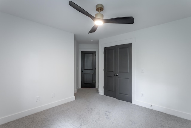 unfurnished bedroom featuring carpet flooring, ceiling fan, and a closet