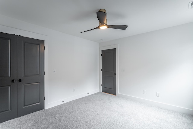 spare room with ceiling fan and light colored carpet