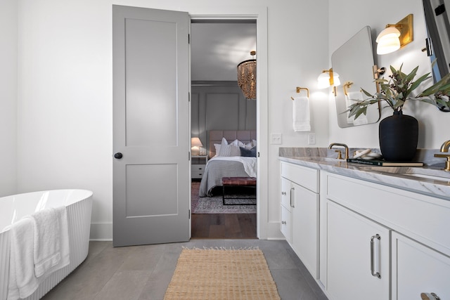 bathroom featuring a bathing tub, vanity, and tile patterned floors