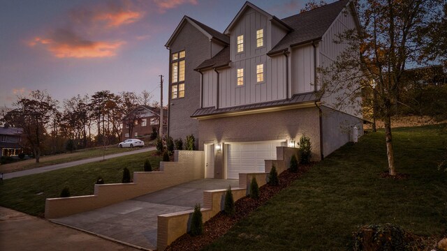 property exterior at dusk featuring a yard and a garage