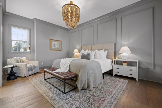 bedroom with a chandelier, hardwood / wood-style floors, and crown molding