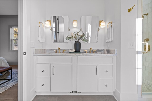 bathroom with hardwood / wood-style flooring, vanity, and a shower with shower door