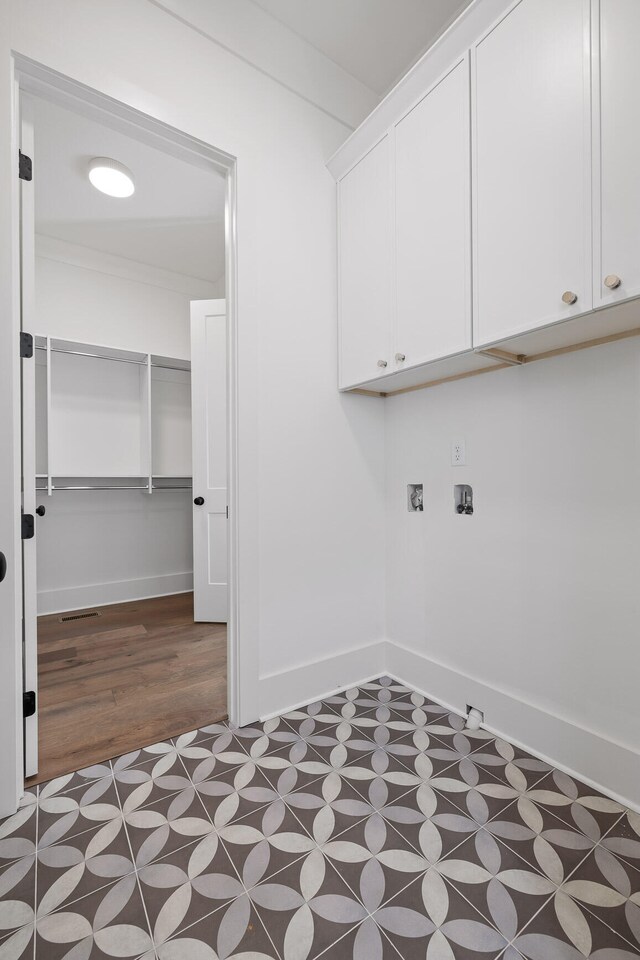 laundry area featuring cabinets, hookup for a washing machine, and dark hardwood / wood-style floors