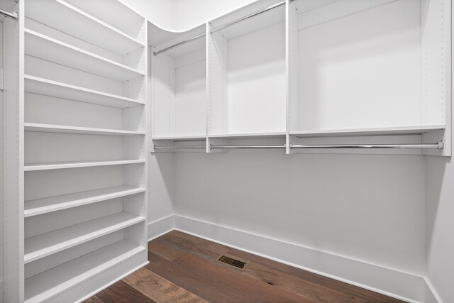 walk in closet with dark hardwood / wood-style flooring