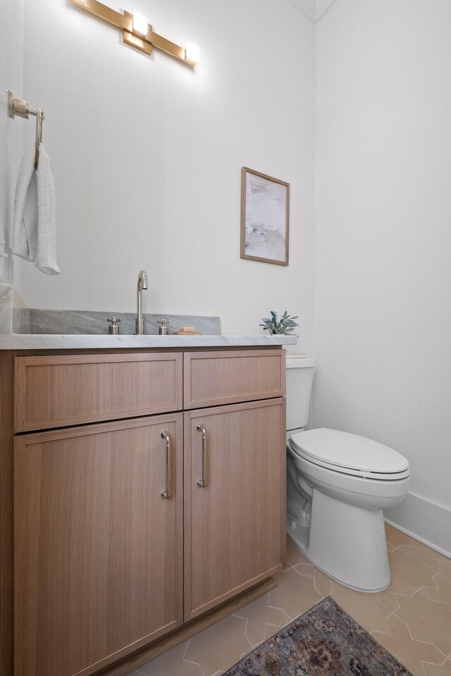 bathroom with tile patterned flooring, vanity, and toilet