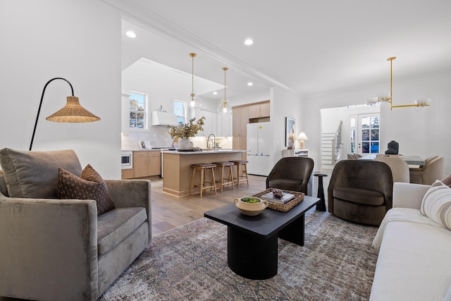 living room with a wealth of natural light, sink, dark wood-type flooring, and an inviting chandelier