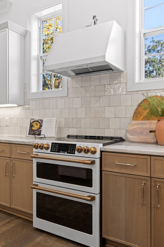 kitchen with tasteful backsplash, island range hood, double oven range, and dark hardwood / wood-style floors