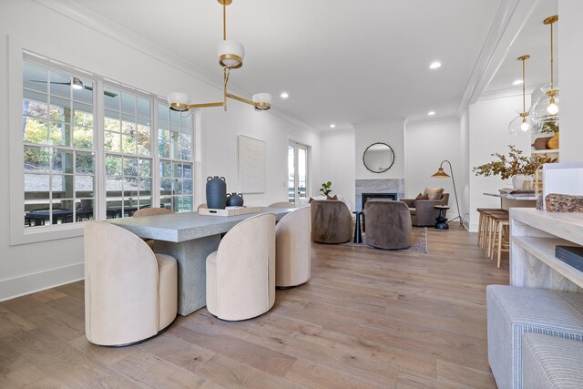 dining area with a fireplace, light wood-type flooring, and plenty of natural light