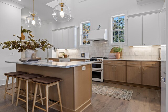 kitchen with white cabinets, dark hardwood / wood-style floors, stove, and custom range hood