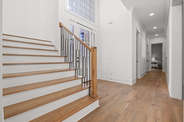 staircase featuring hardwood / wood-style flooring and ornamental molding