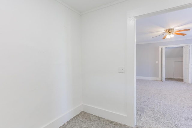 spare room with ceiling fan, ornamental molding, and light carpet