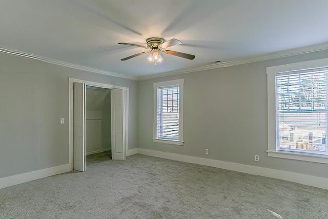 unfurnished bedroom featuring multiple windows, ceiling fan, light carpet, and ornamental molding