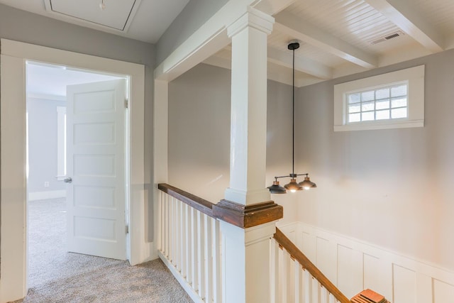 hall with beamed ceiling and light colored carpet