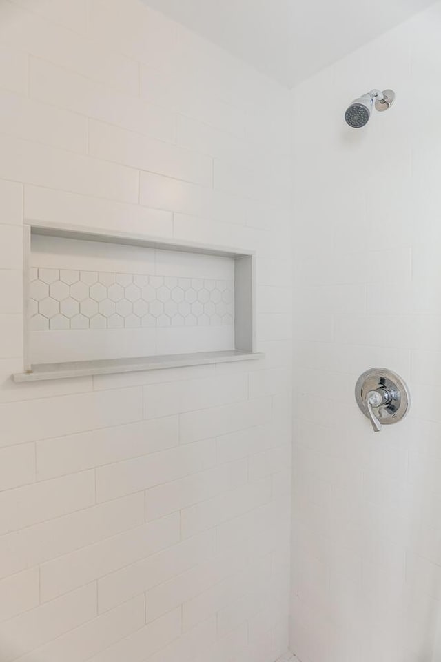 interior details featuring a tile shower