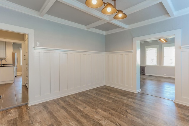 spare room with beamed ceiling, hardwood / wood-style flooring, coffered ceiling, and sink