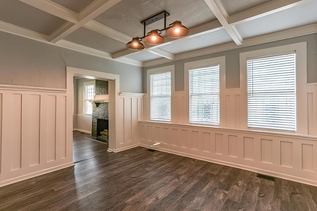 unfurnished dining area featuring coffered ceiling, beamed ceiling, and dark hardwood / wood-style floors