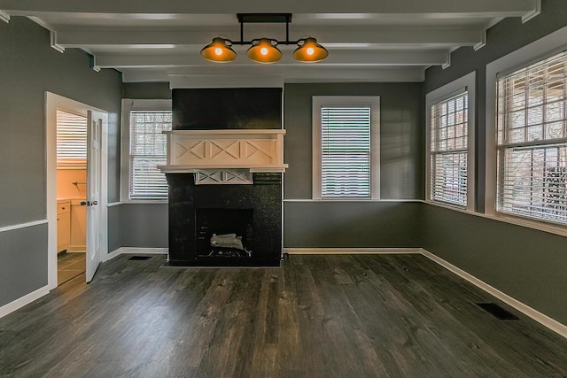 unfurnished living room featuring beam ceiling and dark hardwood / wood-style floors