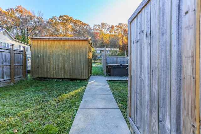 view of outbuilding featuring a lawn and a hot tub