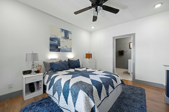 bedroom featuring connected bathroom, ceiling fan, and hardwood / wood-style flooring