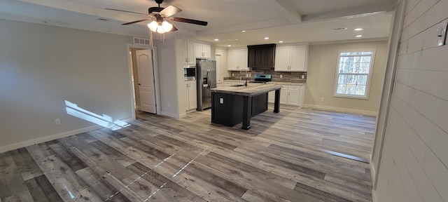 kitchen featuring a center island with sink, white cabinets, ceiling fan, appliances with stainless steel finishes, and light hardwood / wood-style floors