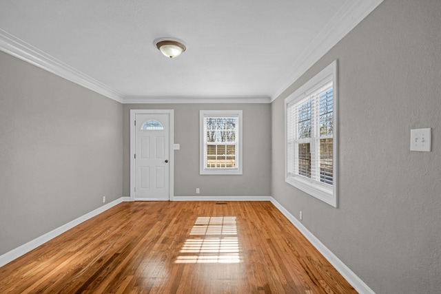 entryway with hardwood / wood-style flooring and ornamental molding