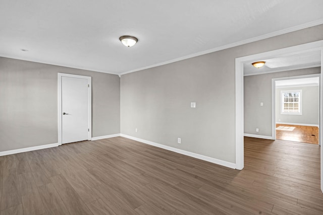 spare room featuring ornamental molding and dark hardwood / wood-style floors