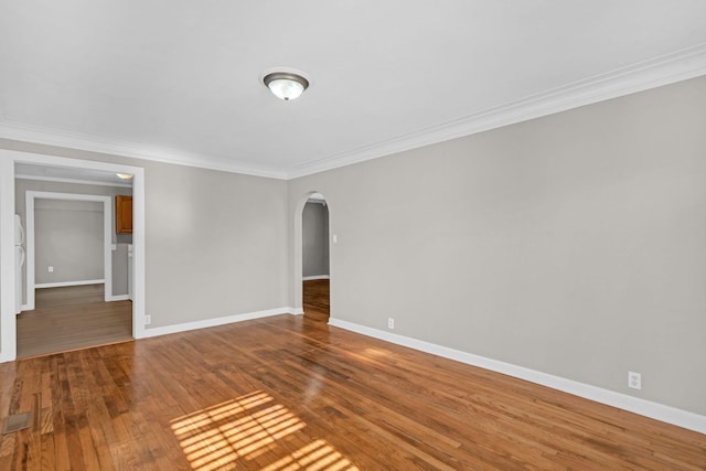 empty room featuring hardwood / wood-style flooring and ornamental molding