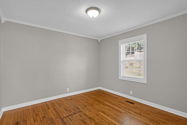 spare room with crown molding and hardwood / wood-style floors