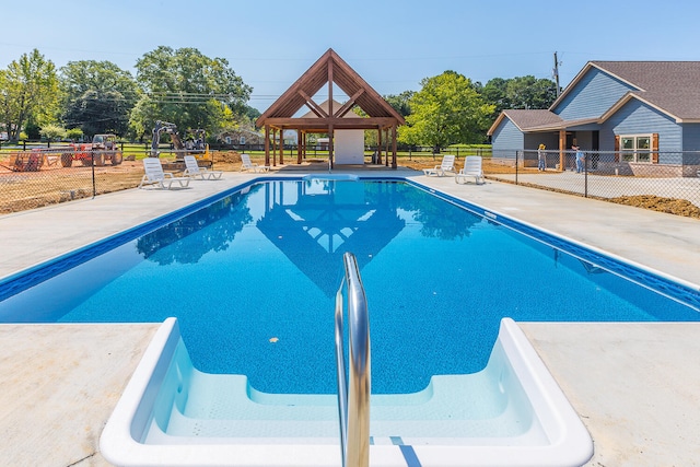 community pool with fence, a gazebo, and a patio