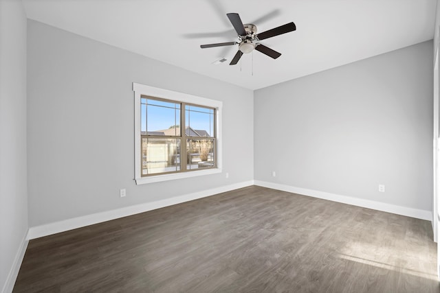 spare room with ceiling fan, dark wood finished floors, and baseboards