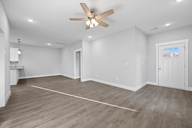 unfurnished living room with dark wood-style floors, recessed lighting, visible vents, and baseboards