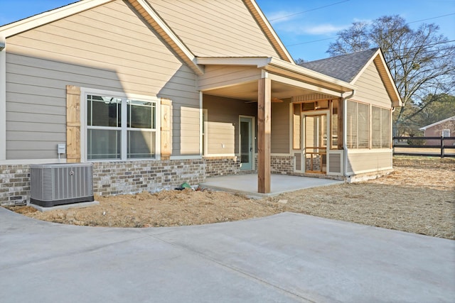 back of house with a patio, central air condition unit, a shingled roof, fence, and a sunroom