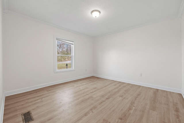 empty room with light wood-type flooring and crown molding