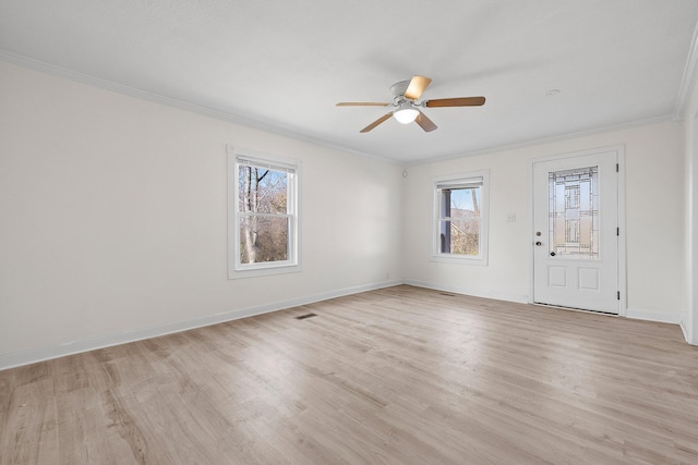 empty room with light hardwood / wood-style flooring, a wealth of natural light, ornamental molding, and ceiling fan