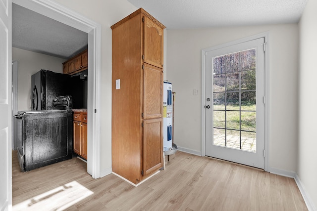 kitchen with a textured ceiling, light wood-type flooring, lofted ceiling, and water heater