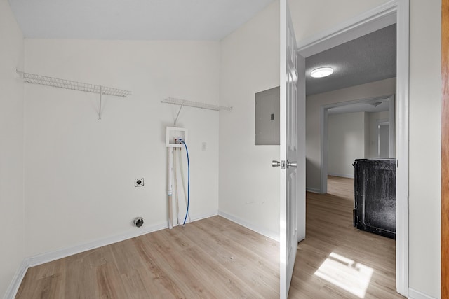 laundry room with hookup for an electric dryer, hookup for a washing machine, a textured ceiling, light hardwood / wood-style flooring, and electric panel