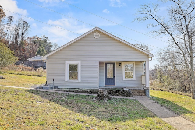 bungalow featuring covered porch and a front lawn